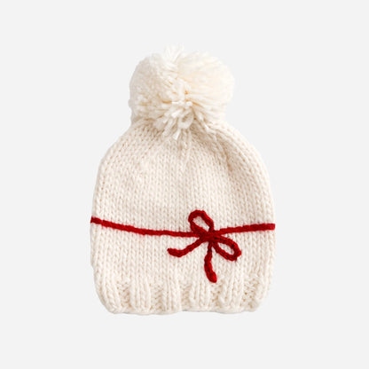 A fun Holiday hat to celebration the biggest gifts in life. Features a yarn Red bow and Cream yarn pom. Pair this hat with the matching sweater or a coordinating cardigan.