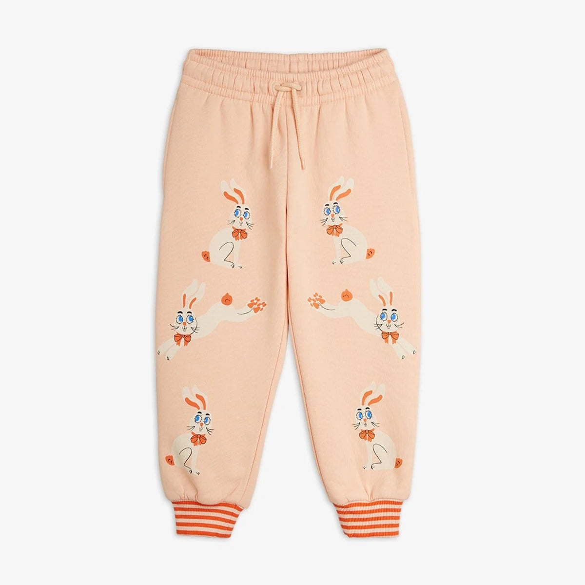 Light peach pink sweatpants featuring a playful cartoon bunny pattern, elastic waistband with drawstring, and orange-and-white striped cuffed ankles, shown flat on a light gray background.