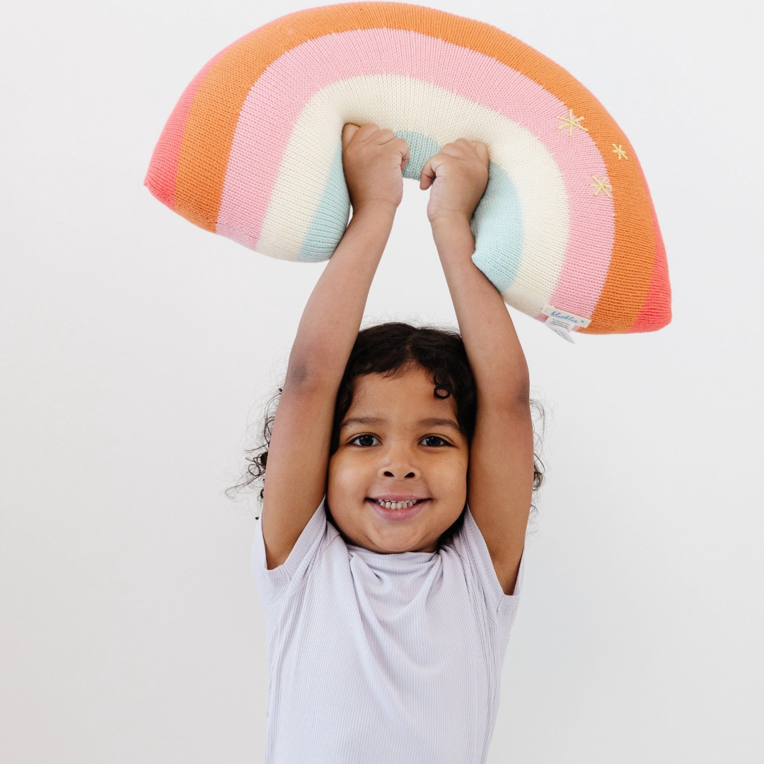 Comfy, colorful, stylish and made of sustainable cotton knit, so it is good for throwing around some color and happiness. One of Blabla's best-sellers! Bright pinks and oranges, inviting textures, a stylish addition to any kid's room. Who wouldn't want to hug a rainbow! Good luck guaranteed!&nbsp;