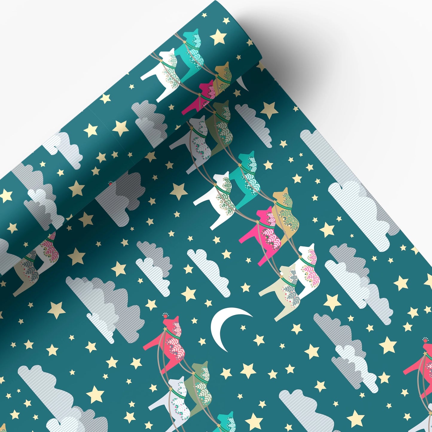 A roll of wrapping paper or fabric with a whimsical night-sky pattern, featuring colorful reindeer, stars, clouds, and a crescent moon on a teal background.