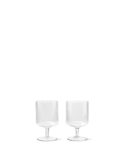 For a casual drink in the garden, the large dinner party or as the fancy supplement at brunch, the Ripple Wine Glass will complete any setting with its unique expression. Mouth-blown into the shape the wine glasses feature the series' characteristic rippled surface and geometric silhouette, making the set of two glasses stack able. Pair the glasses with the rest of the Ripple series and serve your favorite beverage in style.
