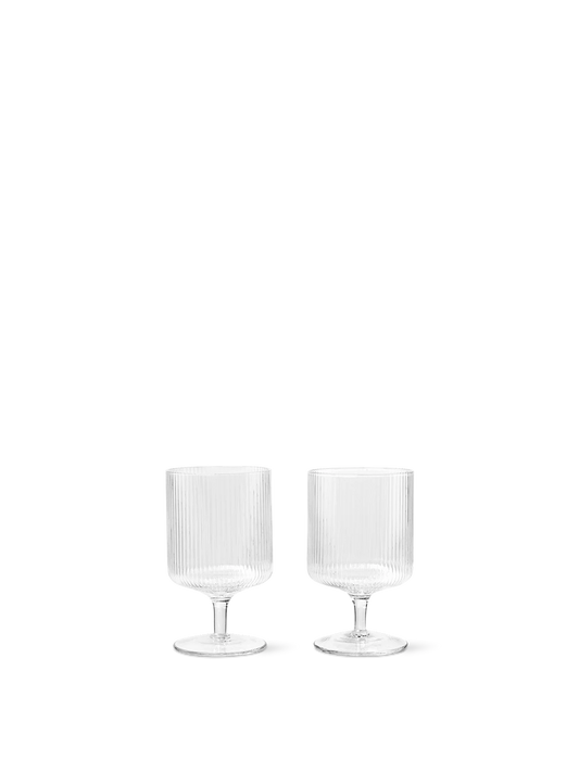 For a casual drink in the garden, the large dinner party or as the fancy supplement at brunch, the Ripple Wine Glass will complete any setting with its unique expression. Mouth-blown into the shape the wine glasses feature the series' characteristic rippled surface and geometric silhouette, making the set of two glasses stack able. Pair the glasses with the rest of the Ripple series and serve your favorite beverage in style.