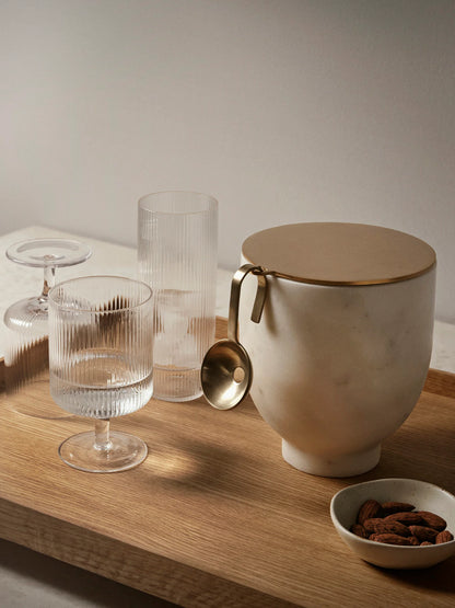 For a casual drink in the garden, the large dinner party or as the fancy supplement at brunch, the Ripple Wine Glass will complete any setting with its unique expression. Mouth-blown into the shape the wine glasses feature the series' characteristic rippled surface and geometric silhouette, making the set of two glasses stack able. Pair the glasses with the rest of the Ripple series and serve your favorite beverage in style.