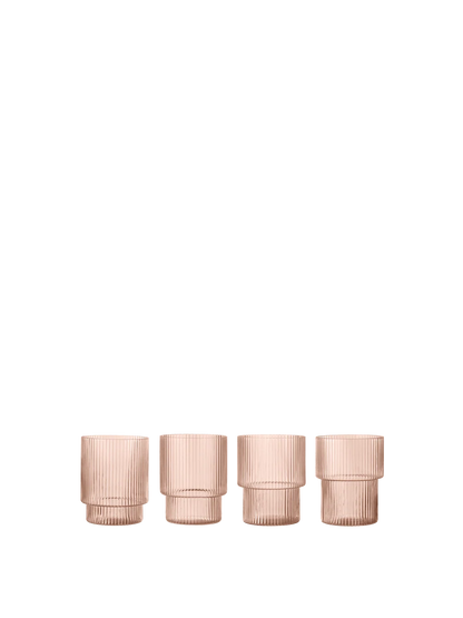 Four ribbed glass tumblers in a translucent pale pink color, arranged in a row against a solid white background.
