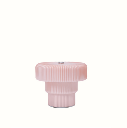 Pink cylindrical Lamp with ribbed texture on a white background