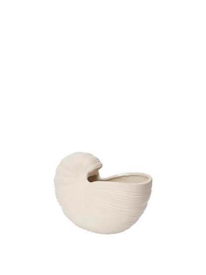 An off-white ceramic planter shaped like a nautilus shell, featuring a ribbed texture and a small opening at the top, shown against a solid white background.