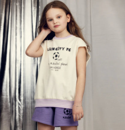 Young girl wearing a 'Lien City FC' t-shirt and purple shorts with a logo.