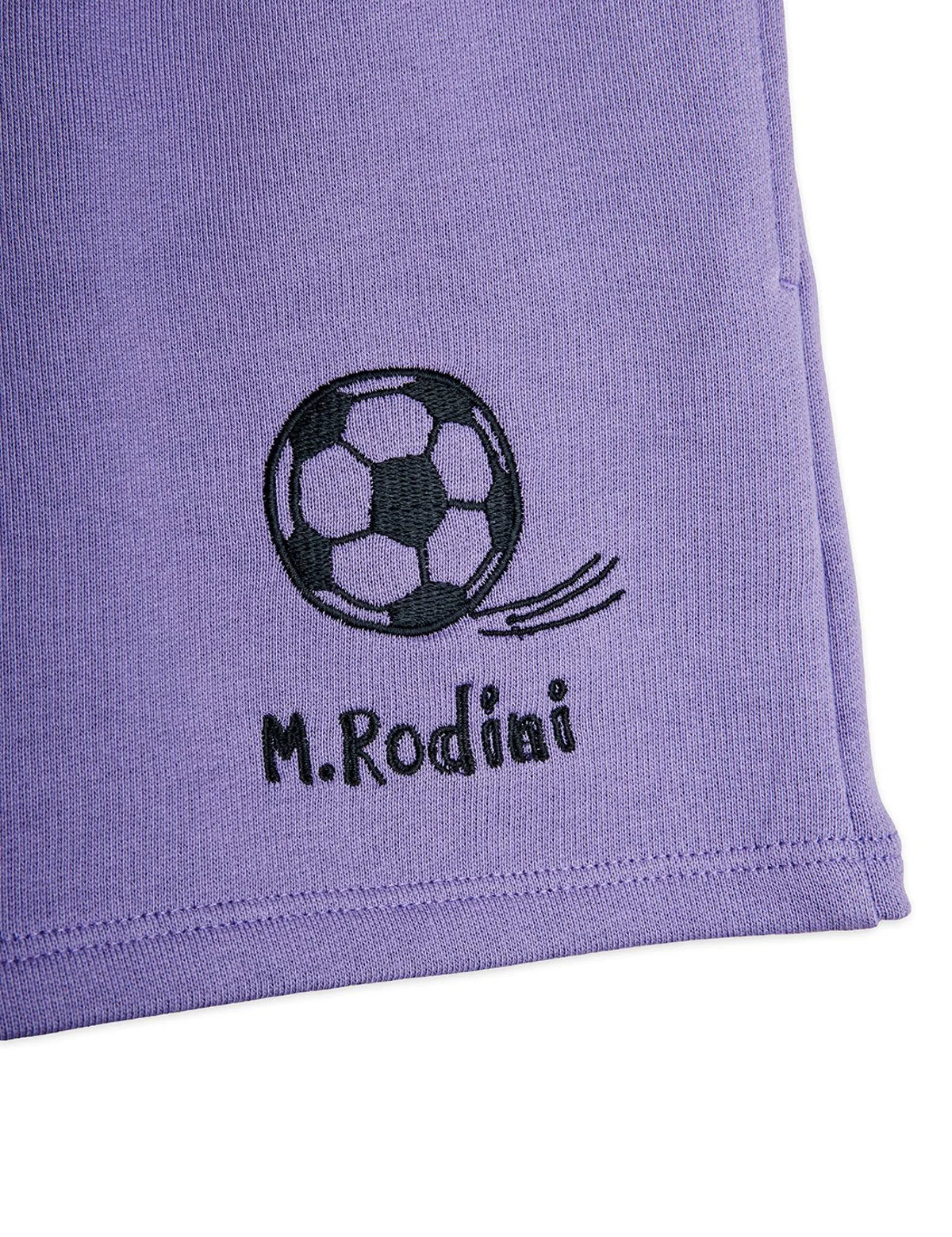 Purple fabric with a soccer ball design and 'M.Rodini' text on a white background