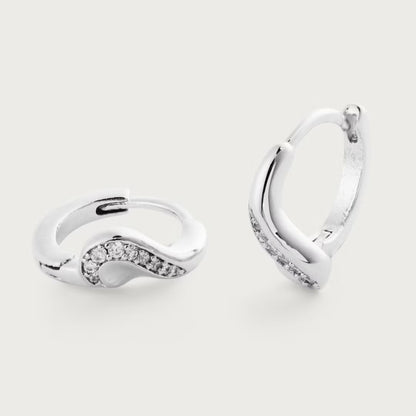Pair of silver hoop earrings with small diamonds on a light gray background