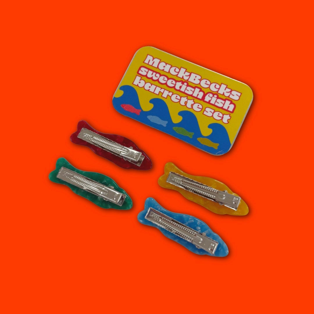 Set of four barrettes on a colorful packaging with 'MackBecks' branding on an orange background.