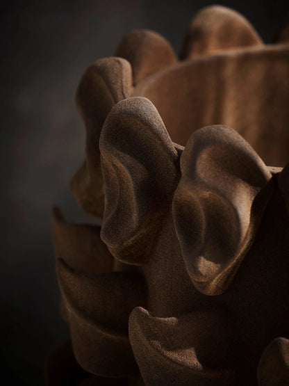 Close-up of a textured brown vase against a dark background