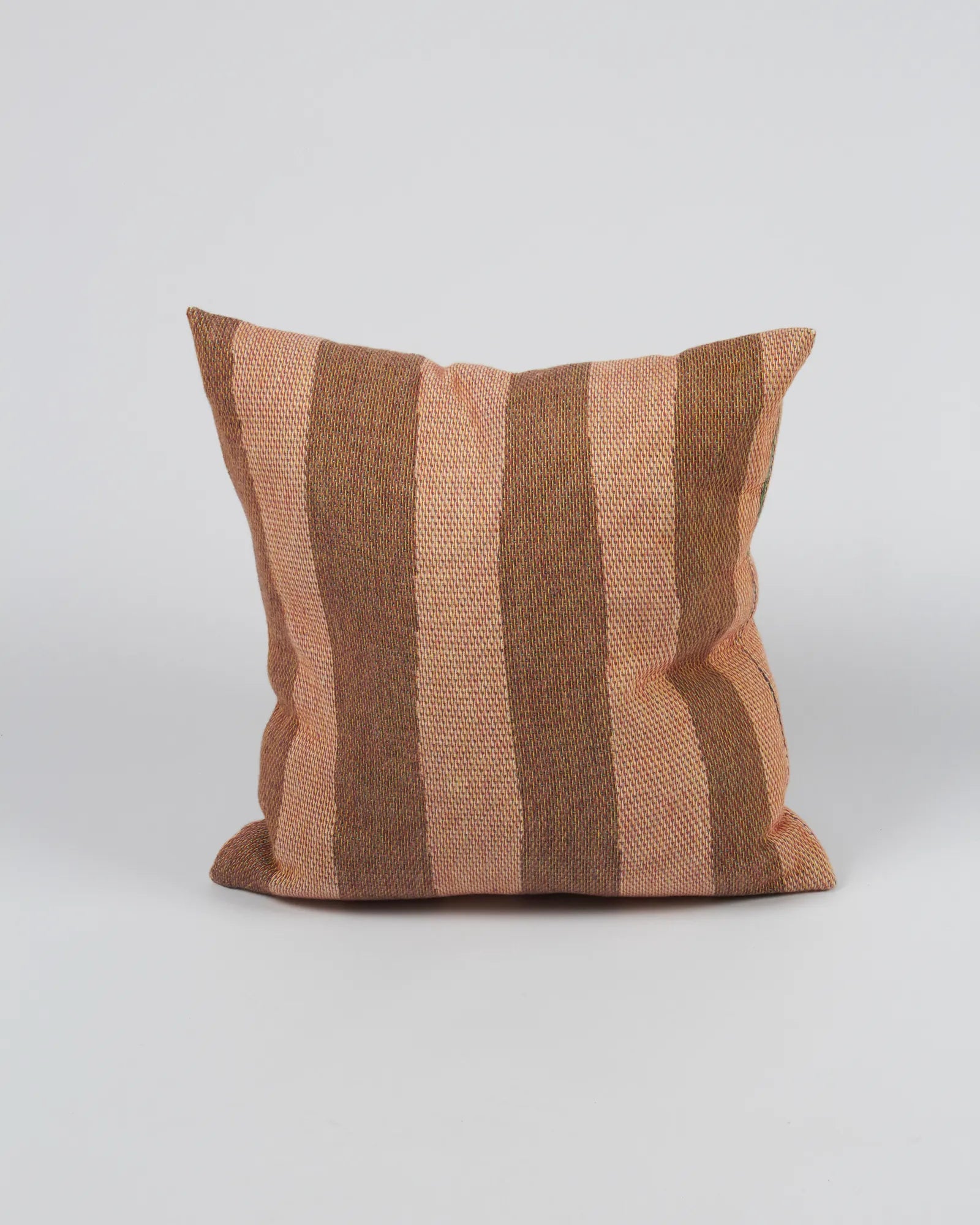 Striped pillow with brown and beige pattern on a light gray background