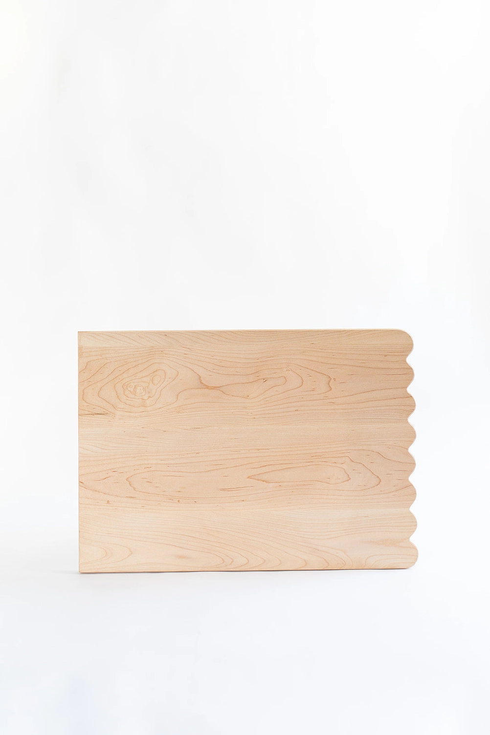 Add whimsical charm to your kitchen with this Scalloped Cutting Board. Handcrafted from solid maple wood and finished with a food grade oil, these cutting boards is a beautiful yet functional addition for daily use.