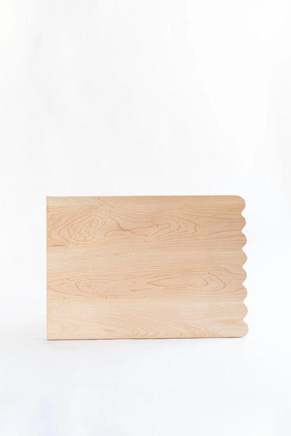 Add whimsical charm to your kitchen with this Scalloped Cutting Board. Handcrafted from solid maple wood and finished with a food grade oil, these cutting boards is a beautiful yet functional addition for daily use.