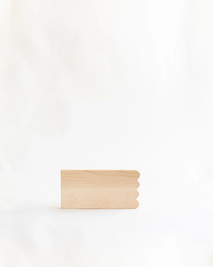 Add whimsical charm to your kitchen with this Scalloped Cutting Board. Handcrafted from solid maple wood and finished with a food grade oil, these cutting boards is a beautiful yet functional addition for daily use.