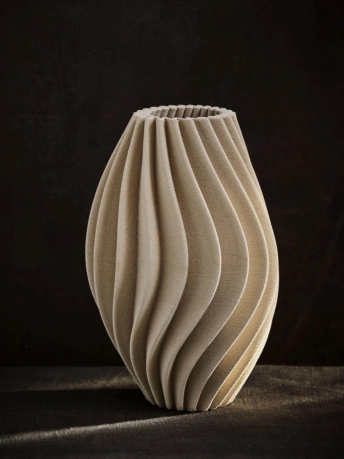 Elegant 3D-printed vase where design meets technology. Each vase features precise lines and intricate details that are difficult to achieve by hand. Made from porcelain clay, the interior is treated to hold water. As the clay is naturally porous, some moisture may pass through, avoid placing it on delicate surfaces. The matte glaze gives a sleek, refined look.