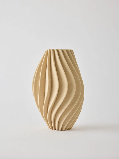 Elegant 3D-printed vase where design meets technology. Each vase features precise lines and intricate details that are difficult to achieve by hand. Made from porcelain clay, the interior is treated to hold water. As the clay is naturally porous, some moisture may pass through, avoid placing it on delicate surfaces. The matte glaze gives a sleek, refined look.