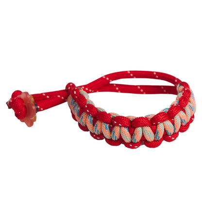 Red braided bracelet with a knot on a white background