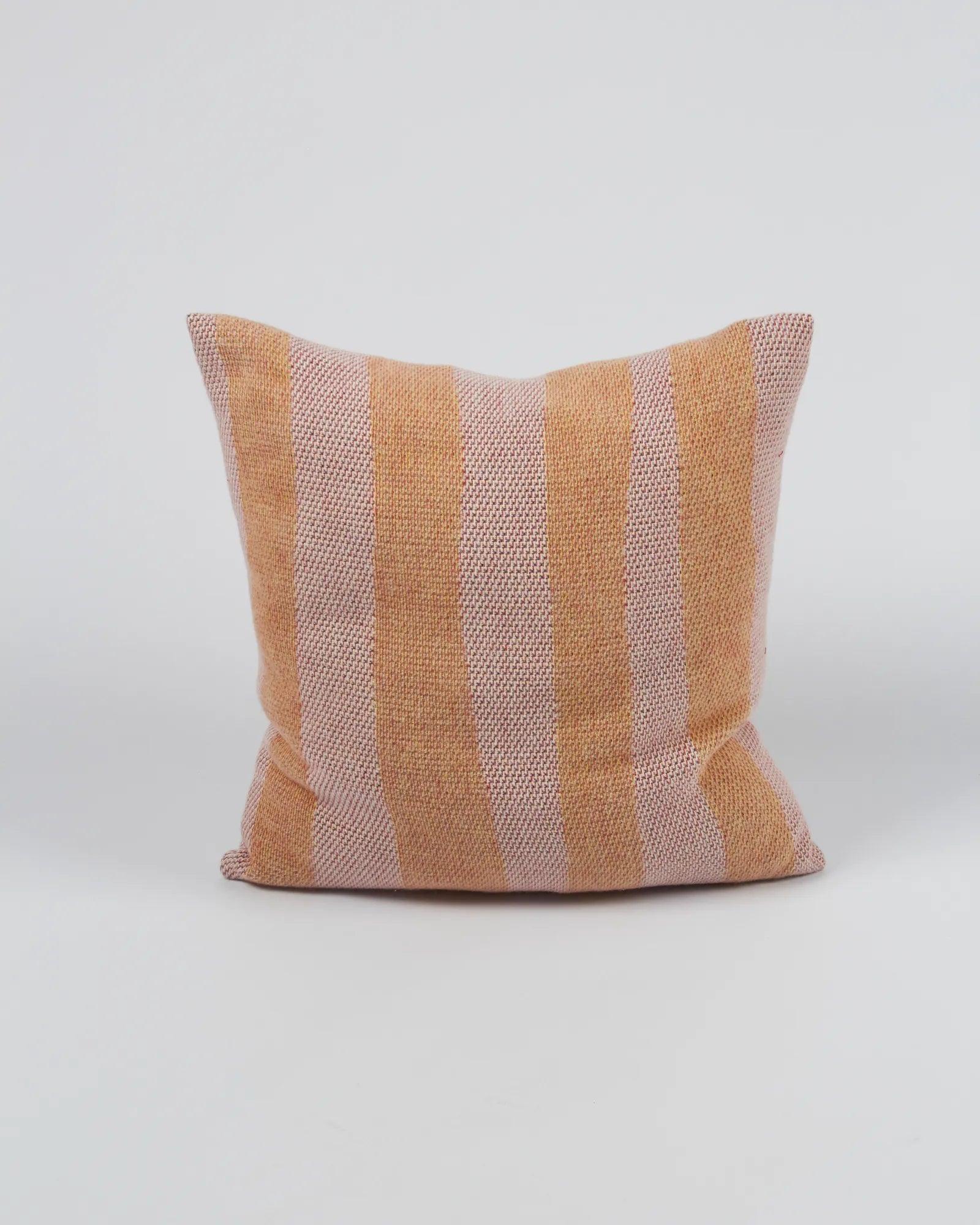 Striped pillow with orange and pink pattern on a white background