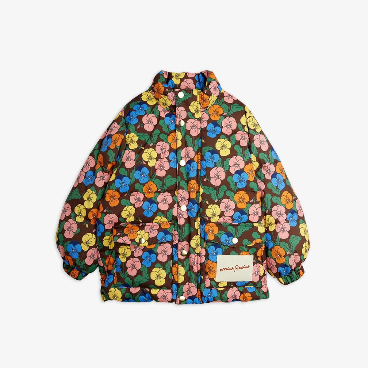 A vintage-style quilted jacket with a dense multicolor floral print on a dark brown base, featuring a stand-up collar, snap-button front, and a cream brand patch on the front pocket.