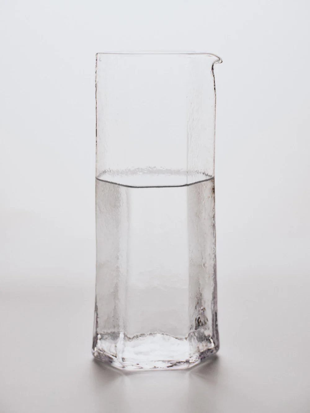 Water filled carafe on white background