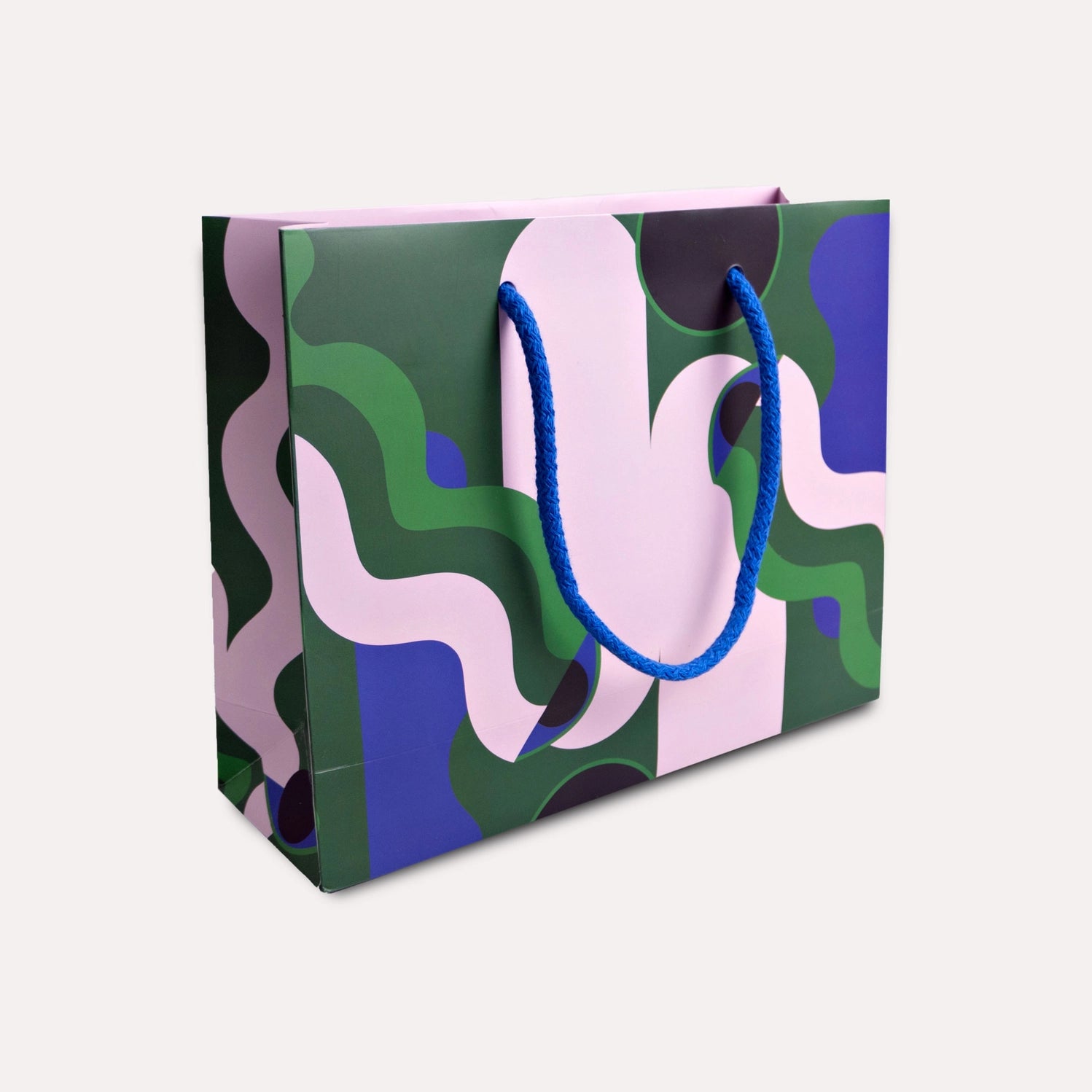 Colorful patterned shopping bag with a blue handle on a light gray background