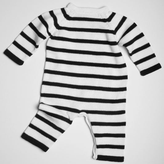 Black and white striped baby romper on a light gray background
