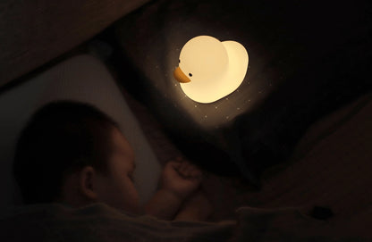 A small duck shaped night lamp designed to accompany you into sleep, a perfect LED night light as bedside table lamp, decoration for dorm, bedroom, nursery, and study room. It features adorable animal appearance, soft and smooth silicone material, comfortable warm yellow light, simple and time-delay switch for versatile and convenience use.