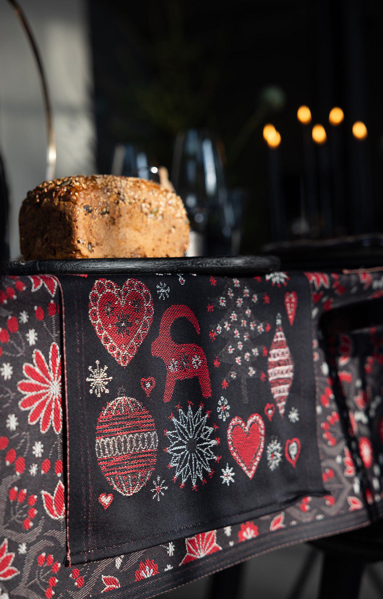 Decorative black fabric with red and white patterns on a dark background