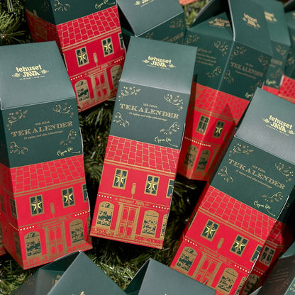 Tea calendar 2025 decorated with a cozy Lundahus in a green and red color scheme. In the calendar you will find 24 different carefully selected teas in compostable tea bags. Enjoy a new cup of tea every day until Christmas Eve!

The tea calendar is opened via the tab on the long side where the door for the teas is hidden.&nbsp;

Contains: 24x3g compostable pyramid tea bags