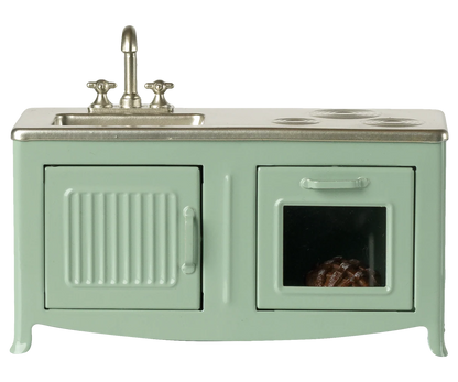Mint green toy kitchen with sink and stove on a white background