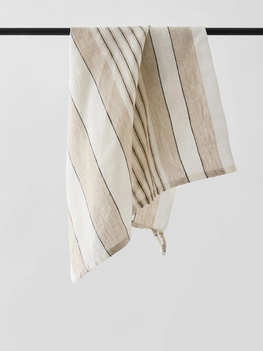 Striped fabric with beige and white stripes on a black rod against a white background