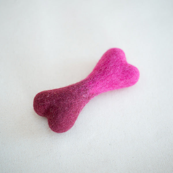 Pink bone-shaped toy on a white background
