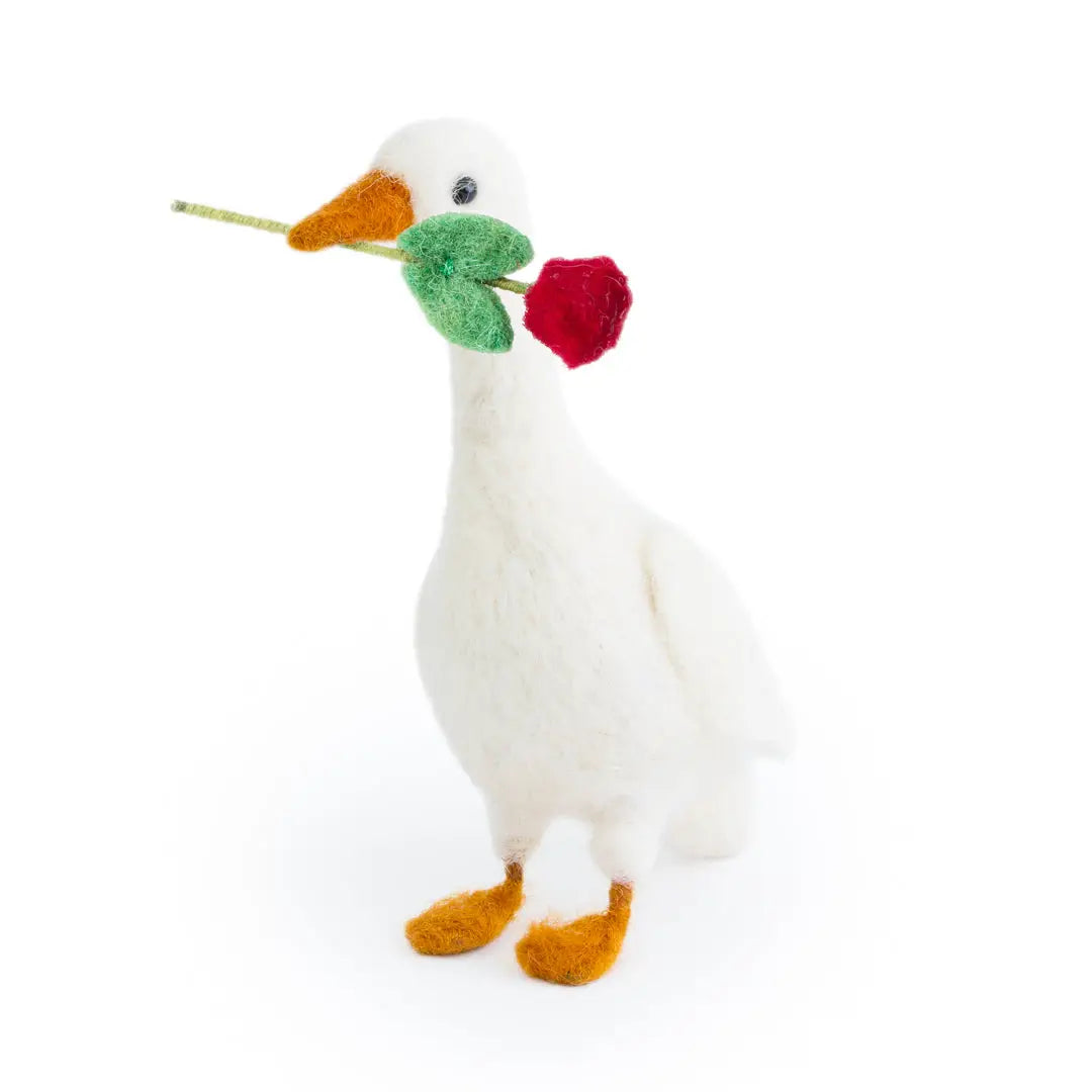 White goose plush toy with a flower in its beak on a white background