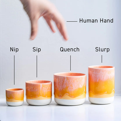 Four ceramic cups with gradient colors labeled from 'Nip' to 'Slurp', with a hand above them.