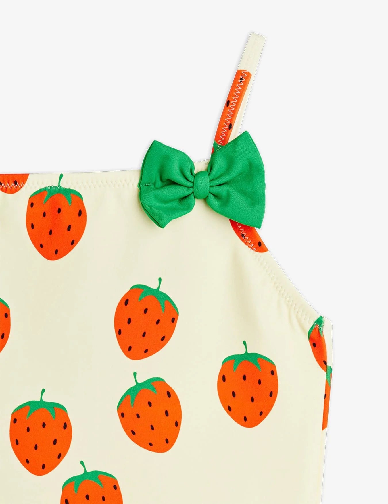 Strawberry-patterned dress with a green bow and straw on a white background