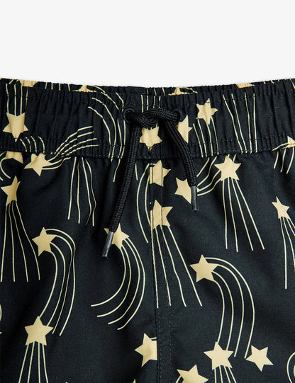 Black shorts with gold star and comet pattern on a white background