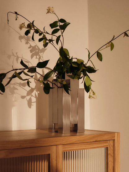 The Tessera Vase brings sculptural character to the home with its striking architectural form. Crafted from mirror-polished stainless steel, it catches and reflects light, adding a dynamic presence to a shelf, dining table, or sideboard. Designed to hold floral arrangements or stand alone as an object in its own right, the vase offers a thoughtful balance of form and function.