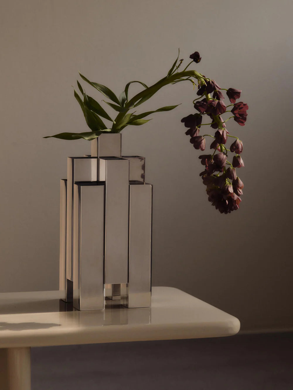 The Tessera Vase brings sculptural character to the home with its striking architectural form. Crafted from mirror-polished stainless steel, it catches and reflects light, adding a dynamic presence to a shelf, dining table, or sideboard. Designed to hold floral arrangements or stand alone as an object in its own right, the vase offers a thoughtful balance of form and function.