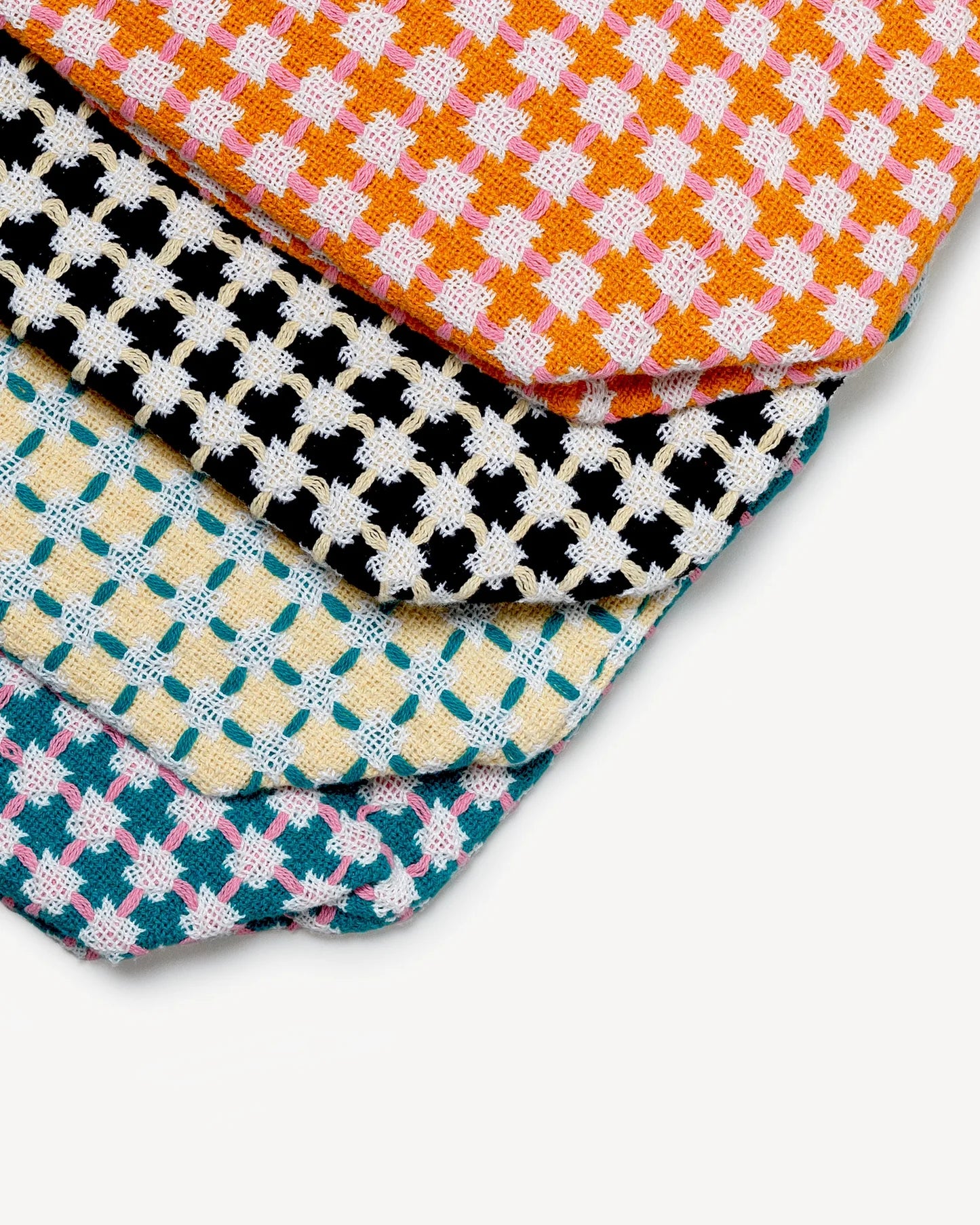 Stack of colorful checkered fabric swatches on a white background
