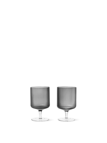 For a casual drink in the garden, the large dinner party or as the fancy supplement at brunch, the Ripple Wine Glass will complete any setting with its unique expression. Mouth-blown into the shape the wine glasses feature the series' characteristic rippled surface and geometric silhouette, making the set of two glasses stack able. Pair the glasses with the rest of the Ripple series and serve your favorite beverage in style.