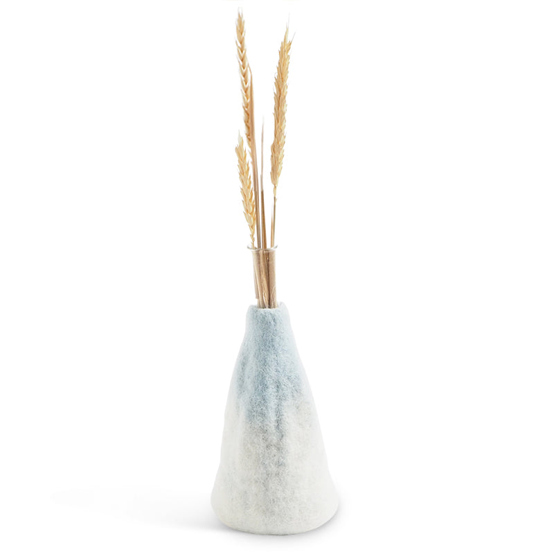 Tapered wool vase with a textured finish holding dried plants on a white background